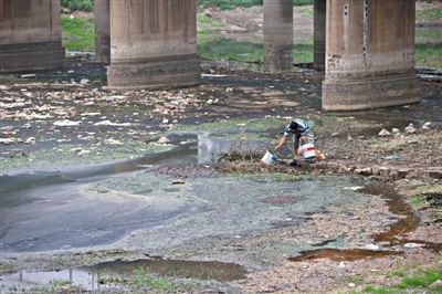 5月27日，一位村民正被嚴重污染的南沙河河道里打水準備澆菜，其下游不遠處，即是沙河水庫。新京報記者 周崗峰 攝